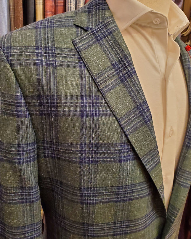 Green plaid fabric with a beige shirt underneath, on a wooden surface.