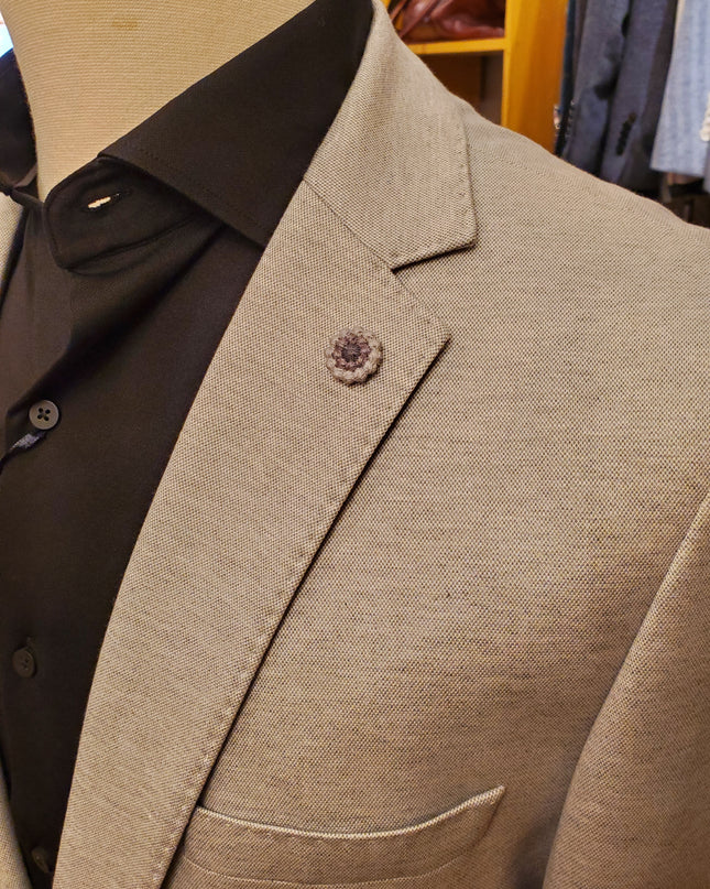 Close-up of a brown suit jacket with a button on a blurred background